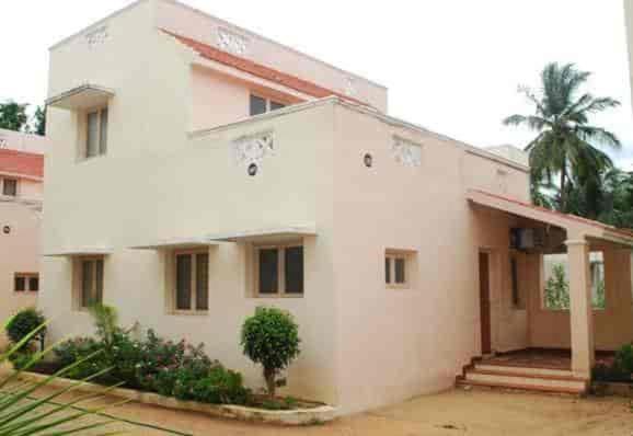 ein weißes Haus mit einer Palme davor in der Unterkunft SRI SANKARA VILLAS -- Aditya Heritage in Kumbakonam