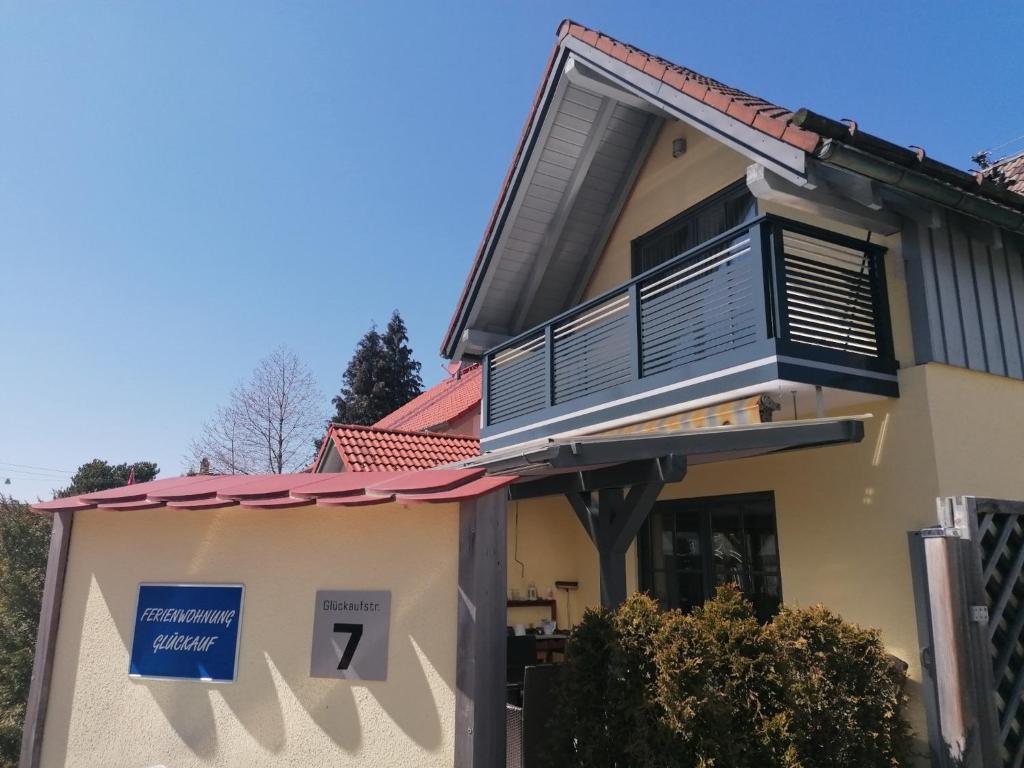 una casa con un balcón con un cartel. en Ferienwohnung Glückauf, en Peiting