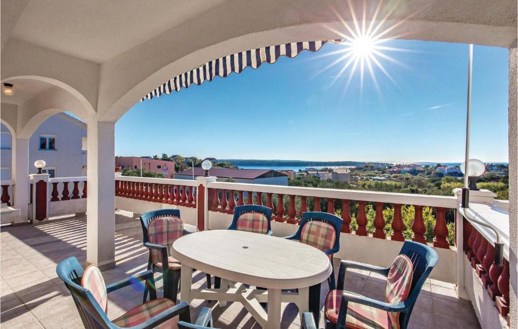 patio ze stołem i krzesłami na balkonie w obiekcie Nice Apartment In Banjol With Kitchen w mieście Banjol