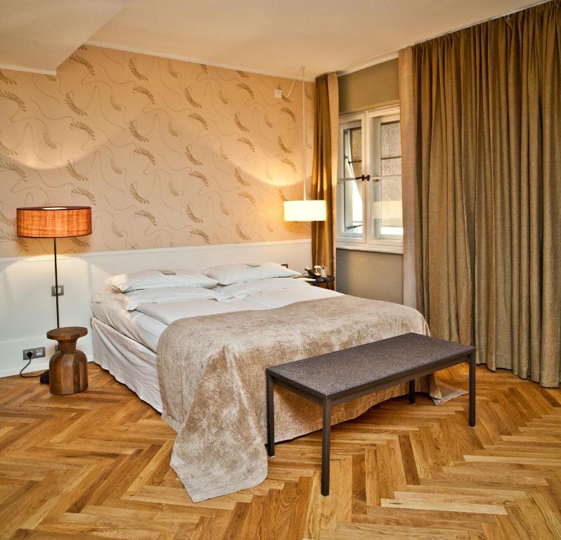 a bedroom with a large bed and a table at CORTIINA Hotel in Munich