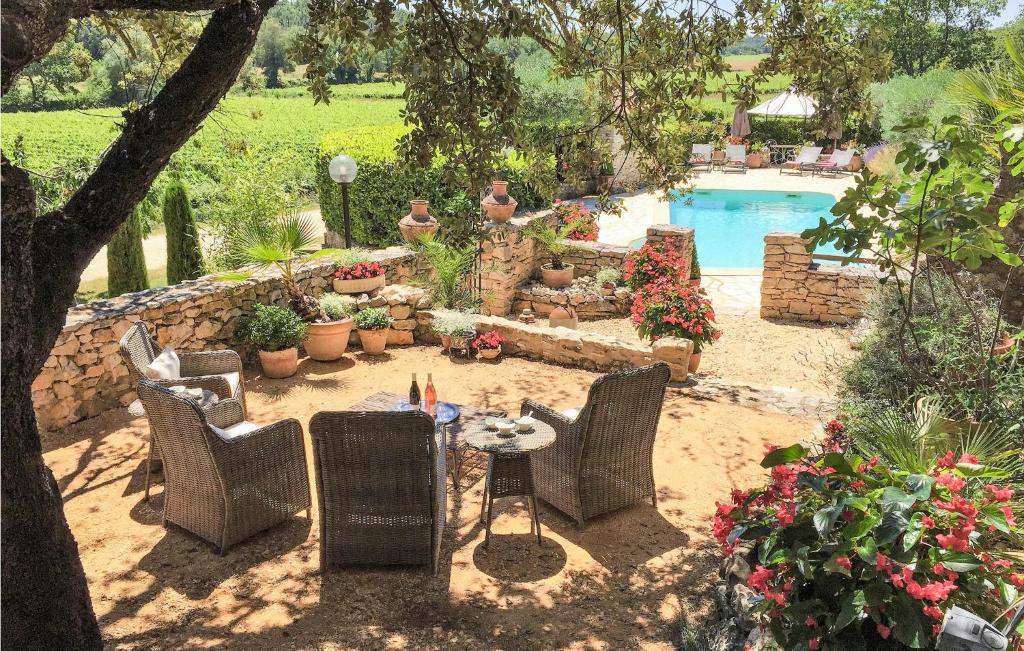 a patio with chairs and a table and a pool at Awesome Home In Fontarches With 2 Bedrooms, Wifi And Outdoor Swimming Pool in Fontarèches