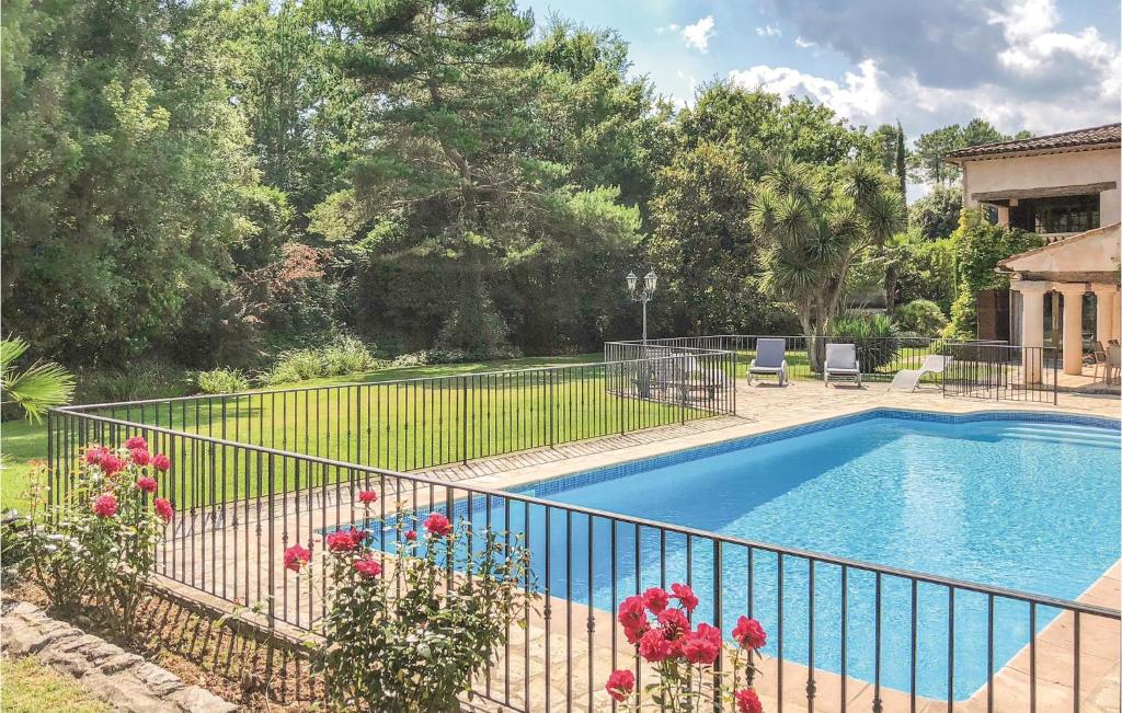 una piscina en un patio con una valla y flores en Gorgeous Home In Callian With Kitchen, en Callian