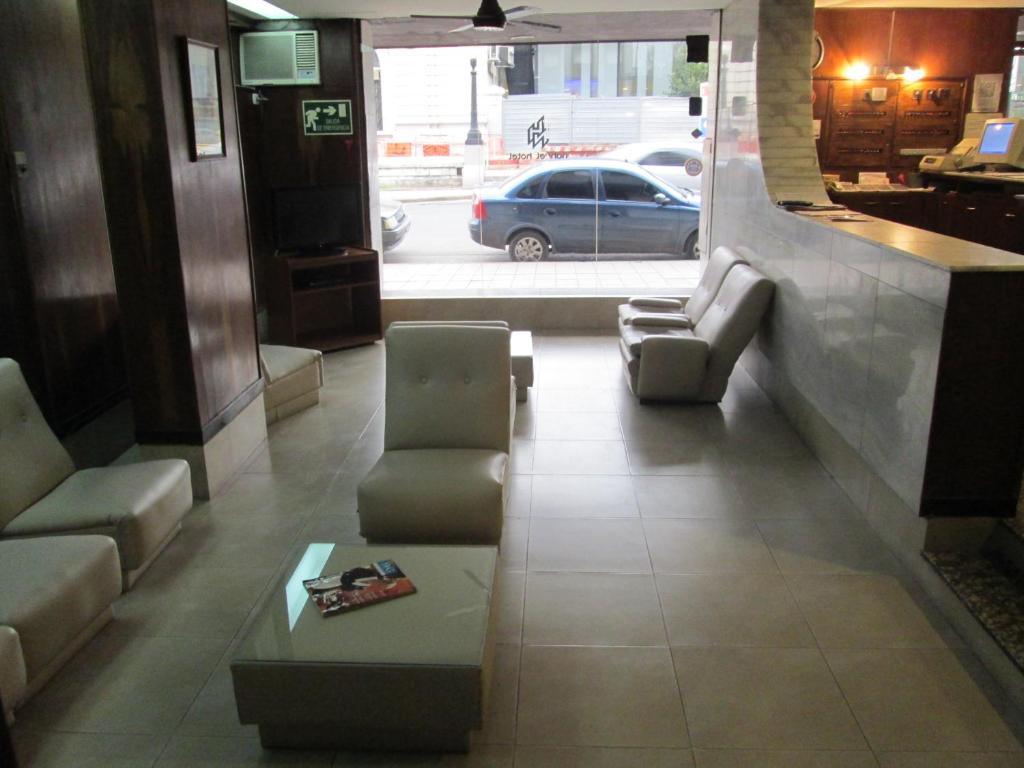 a living room with a couch and chairs and a table at Hotel Nahuel in Rosario