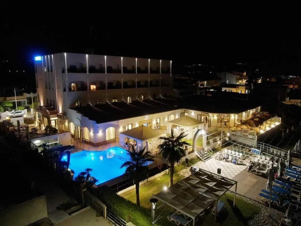 a large building with a swimming pool at night at Hotel Il Gabbiano Beach in Terme Vigliatore