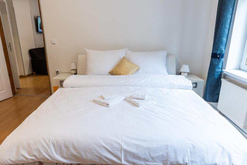 uma grande cama branca com dois guardanapos em Lukas Apartments em Jáchymov