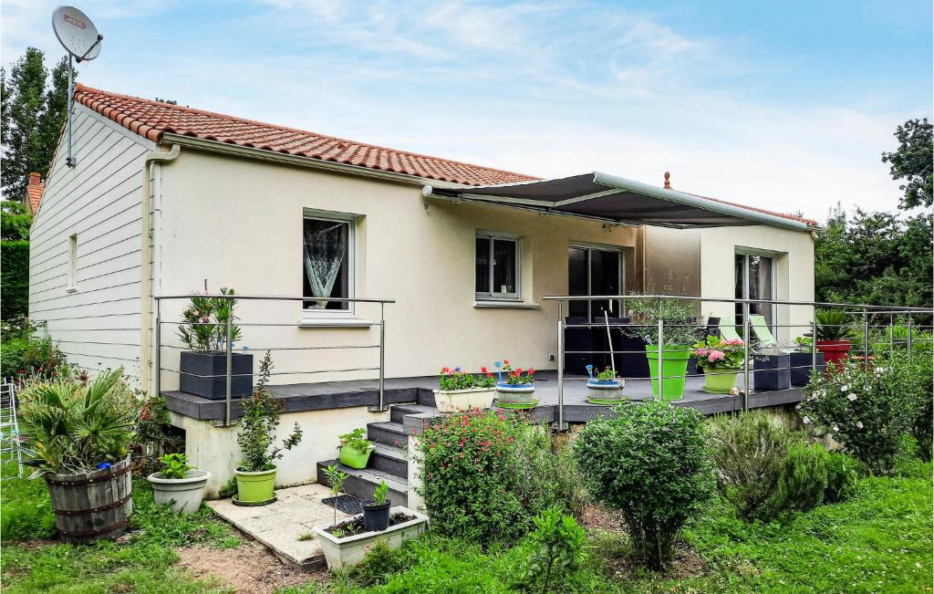 une maison dotée d'une terrasse avec des plantes en pot dans l'établissement Two-Bedroom Holiday Home In St Michel Chef Chef, à Saint-Michel-Chef-Chef