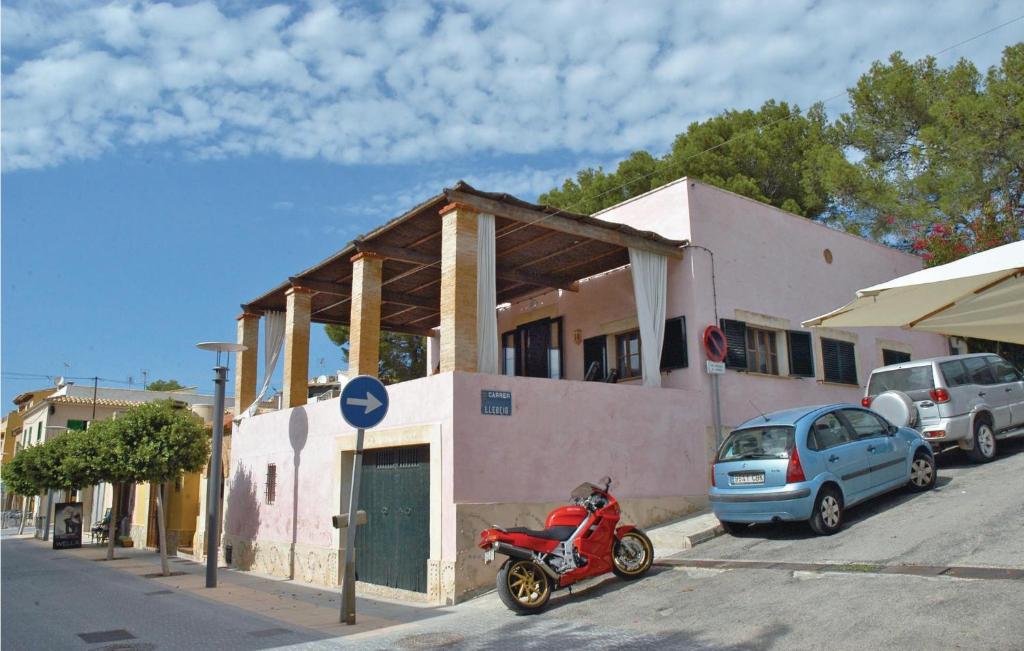 uma scooter vermelha estacionada em frente a um edifício em Nice Home In San Telmo With 3 Bedrooms em Sant Elm