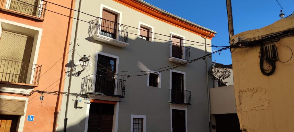 - un bâtiment blanc avec des fenêtres et des balcons dans une rue dans l'établissement Ca Sanchis, piso en el casco antiguo, à Xàtiva