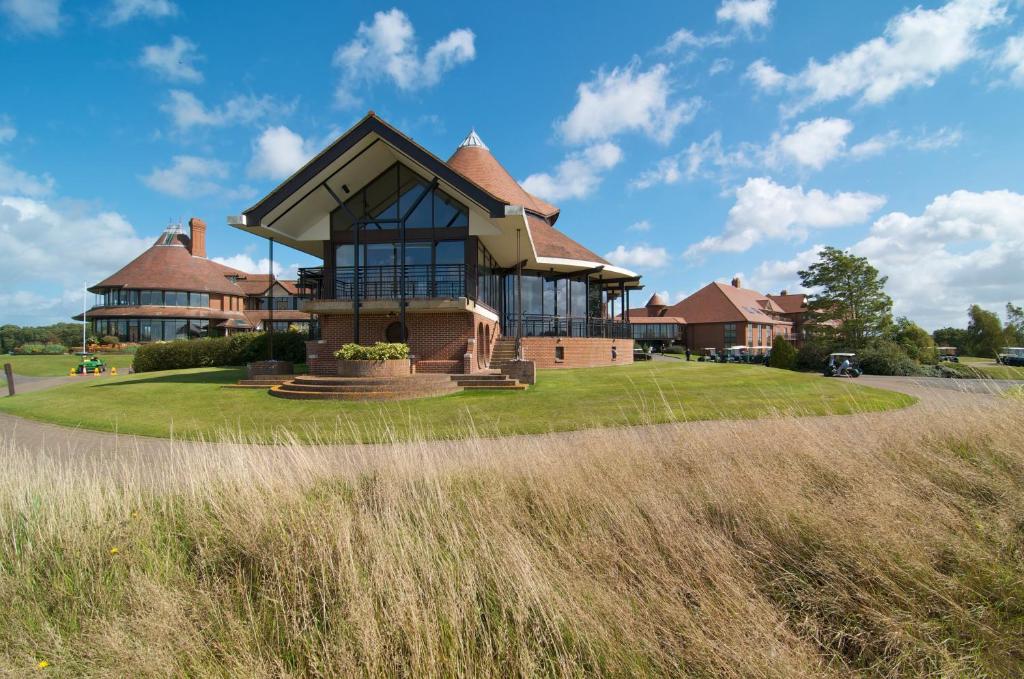 a large brick building with a view of a grassy field at East Sussex National Hotel, Golf Resort & Spa in Uckfield