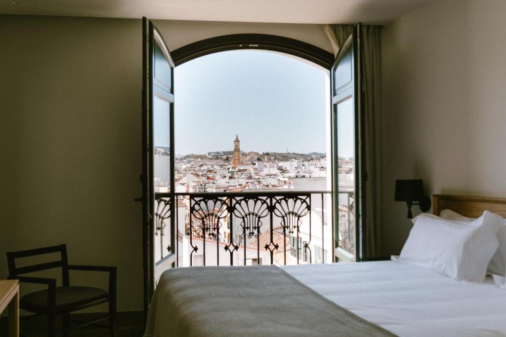 1 dormitorio con cama y vistas a la ciudad en Hotel Estepona Plaza en Estepona