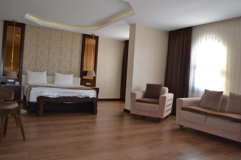 a hotel room with a bed and a couch and a chair at Gulumser Hatun Termal Hotel & Spa in Derekoy