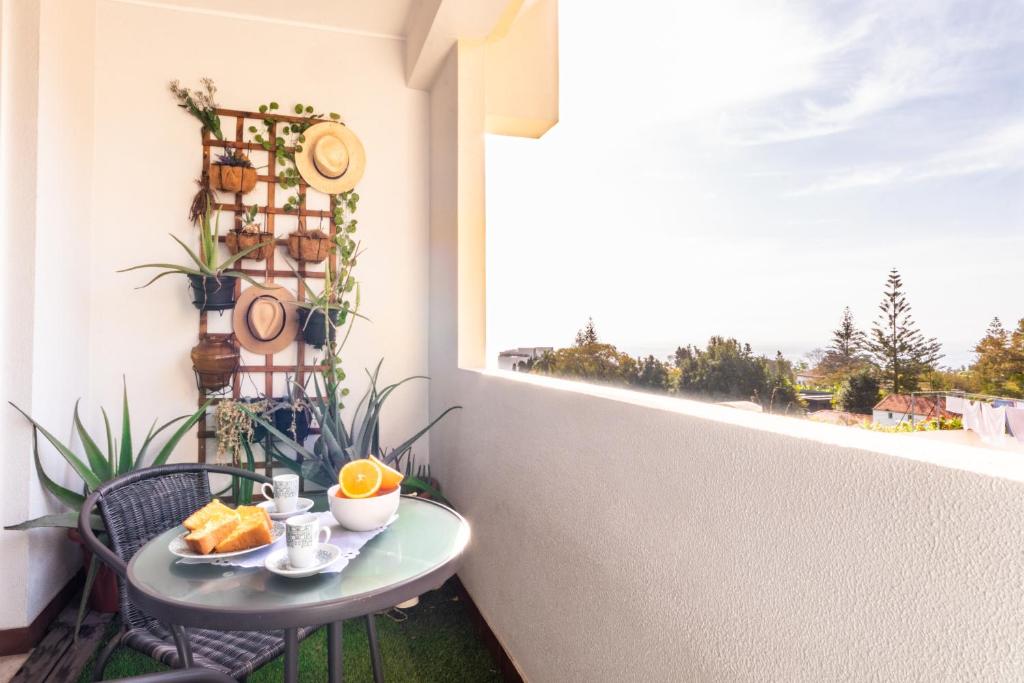 フンシャルにあるMaria Casa Branca by ALMA Holiday Rentalsの窓付きのバルコニーにオレンジ付きのテーブル