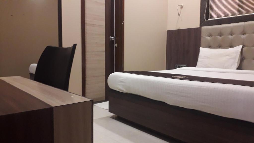 ムンバイにあるShine Hospitality Crownのベッドルーム1室(ベッド1台、デスク、テーブル付)