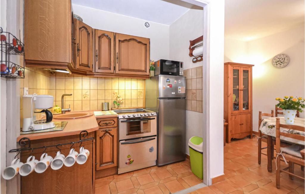 a kitchen with wooden cabinets and stainless steel appliances at Beautiful Home In Entrechaux With 1 Bedrooms And Wifi in Entrechaux