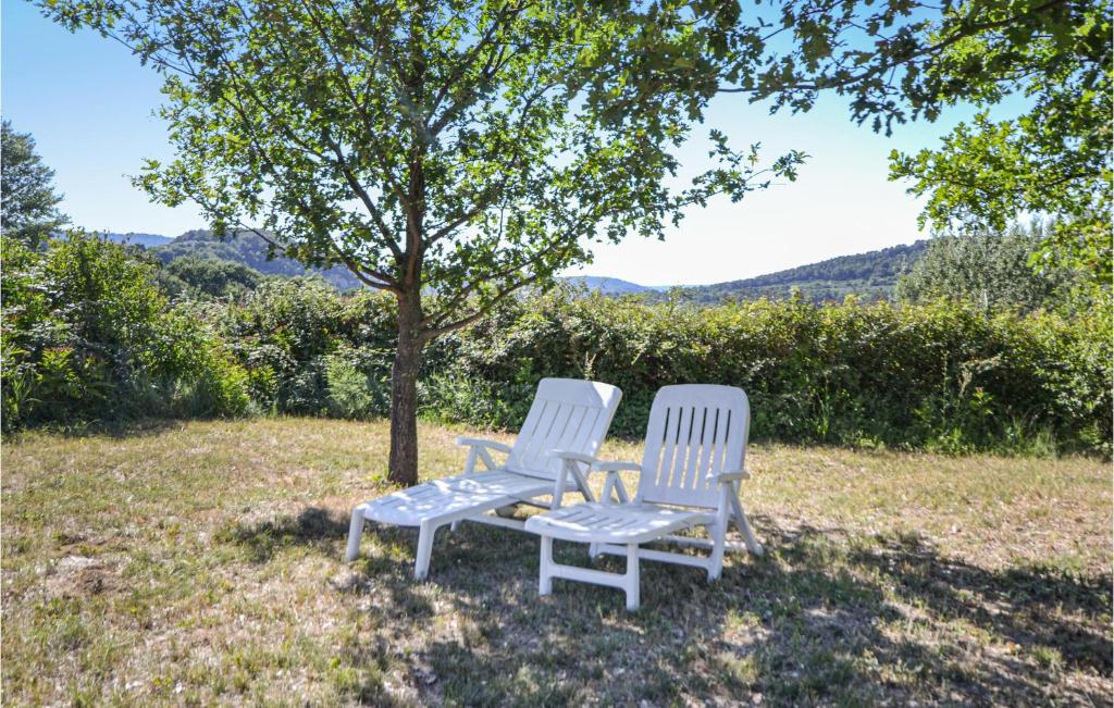 two chairs sitting under a tree in a field at Beautiful Home In Entrechaux With 1 Bedrooms And Wifi in Entrechaux