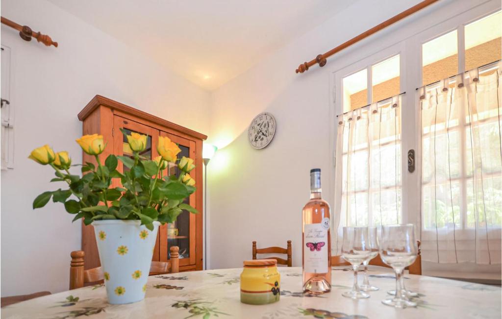 a bottle of wine and a vase of flowers on a table at Beautiful Home In Entrechaux With 1 Bedrooms And Wifi in Entrechaux