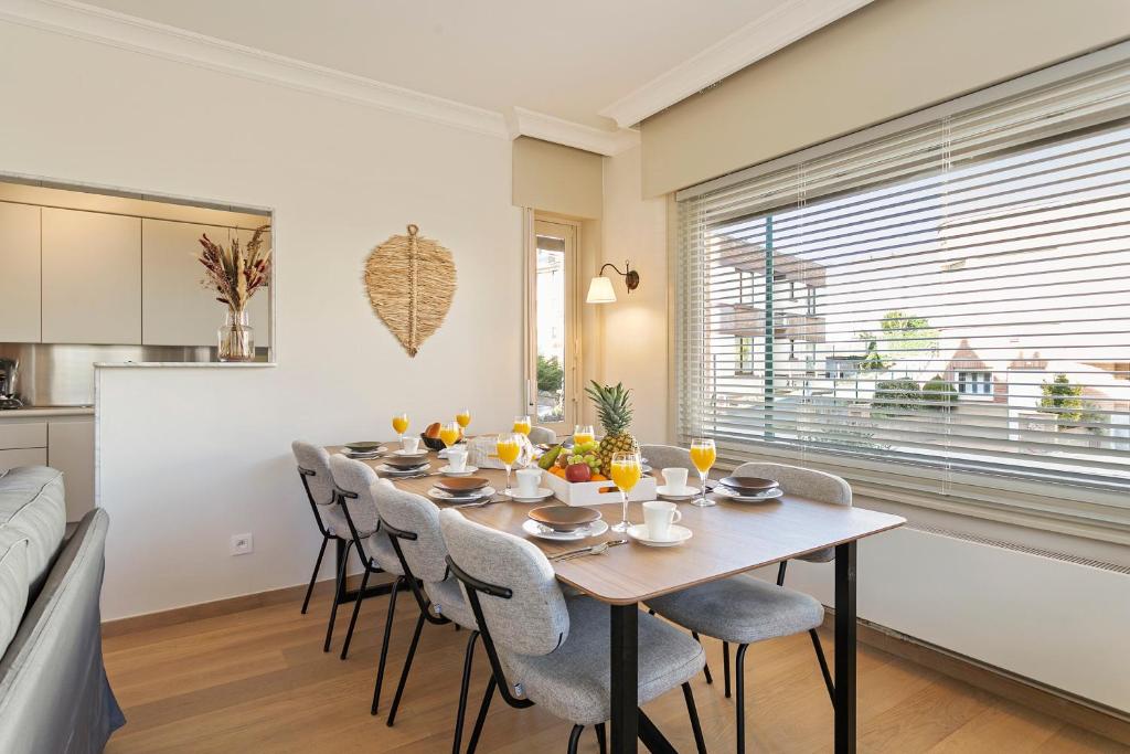 a dining room with a table and chairs and a kitchen at Maison Emile in De Panne