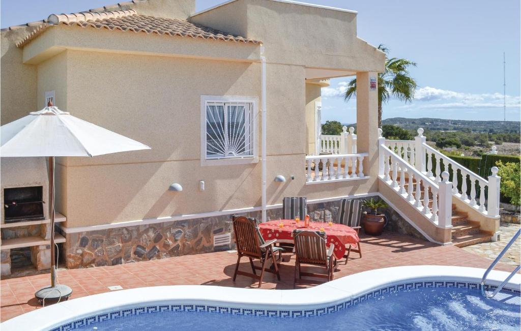 a villa with a table and chairs and a swimming pool at Beautiful Home In Quesada-Rojales in Rojales