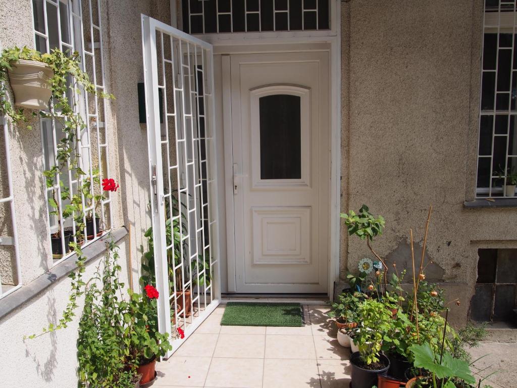 a white door on a building with plants at Sakuranbo - Guest House in Budapest