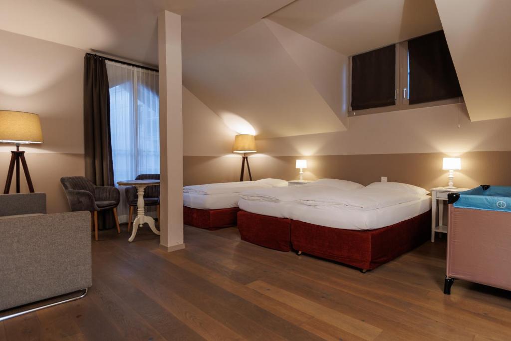 una camera d'albergo con due letti e un tavolo di Hotel Emmental a Thun