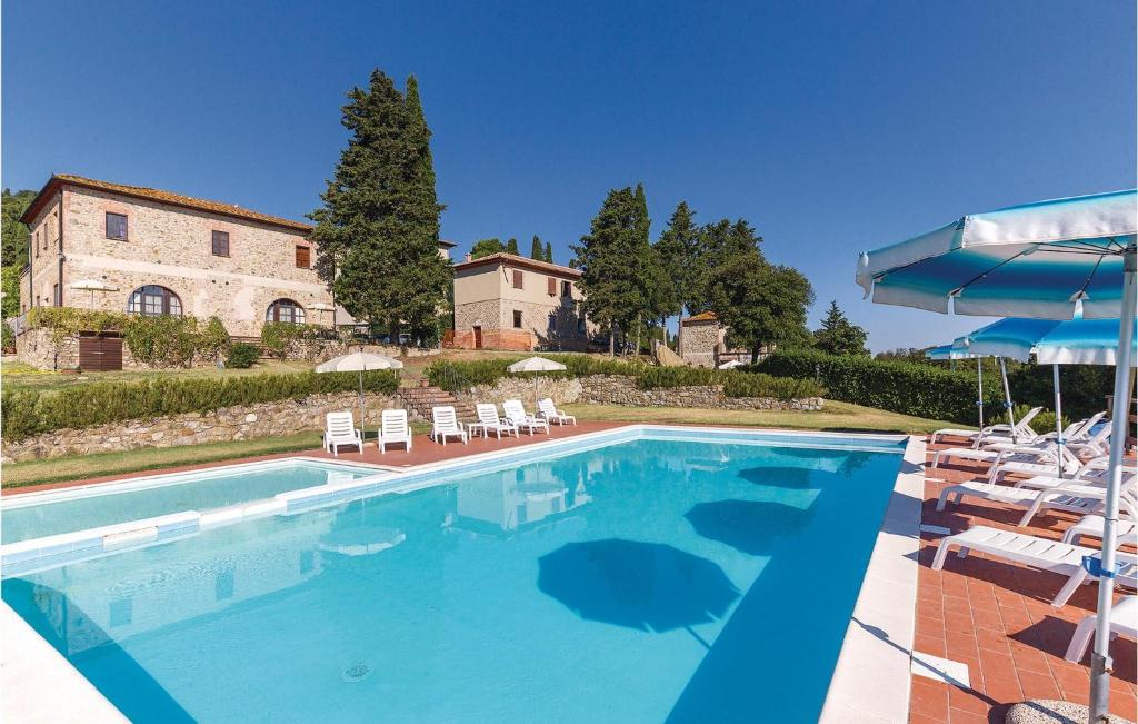 una gran piscina con sillas y una casa en Monterufoli 3v, en Pomarance