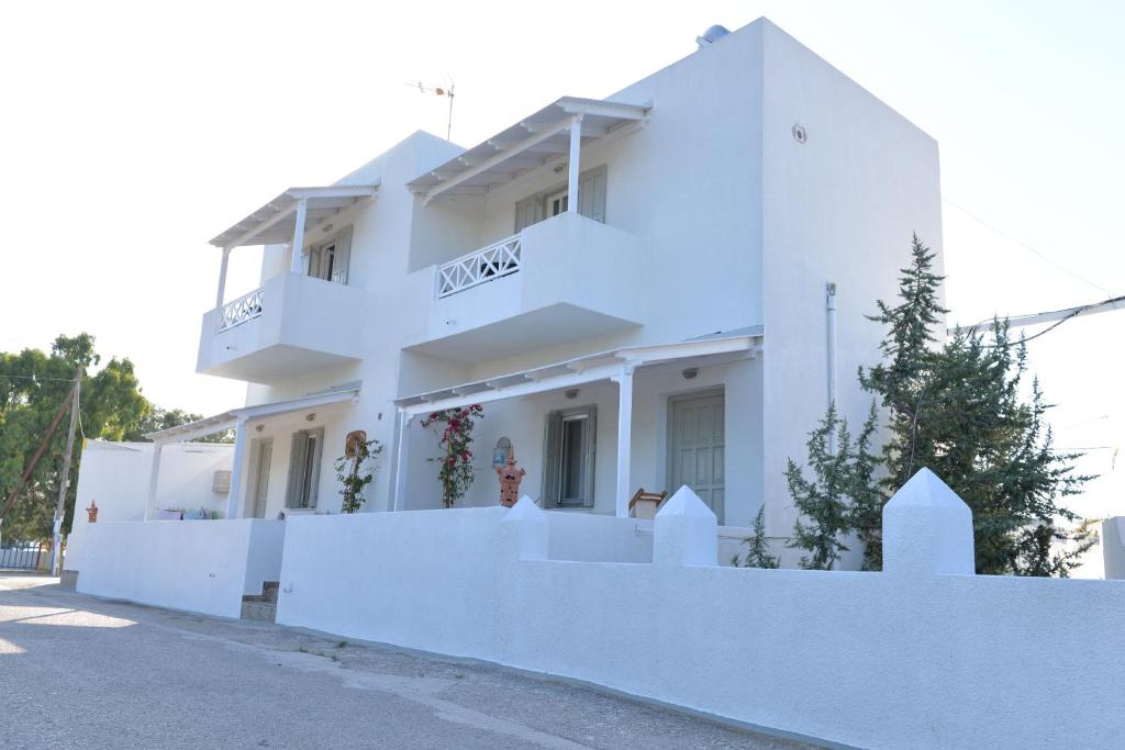 a white house with a white fence in front of it at Kalimera Studios in Pollonia