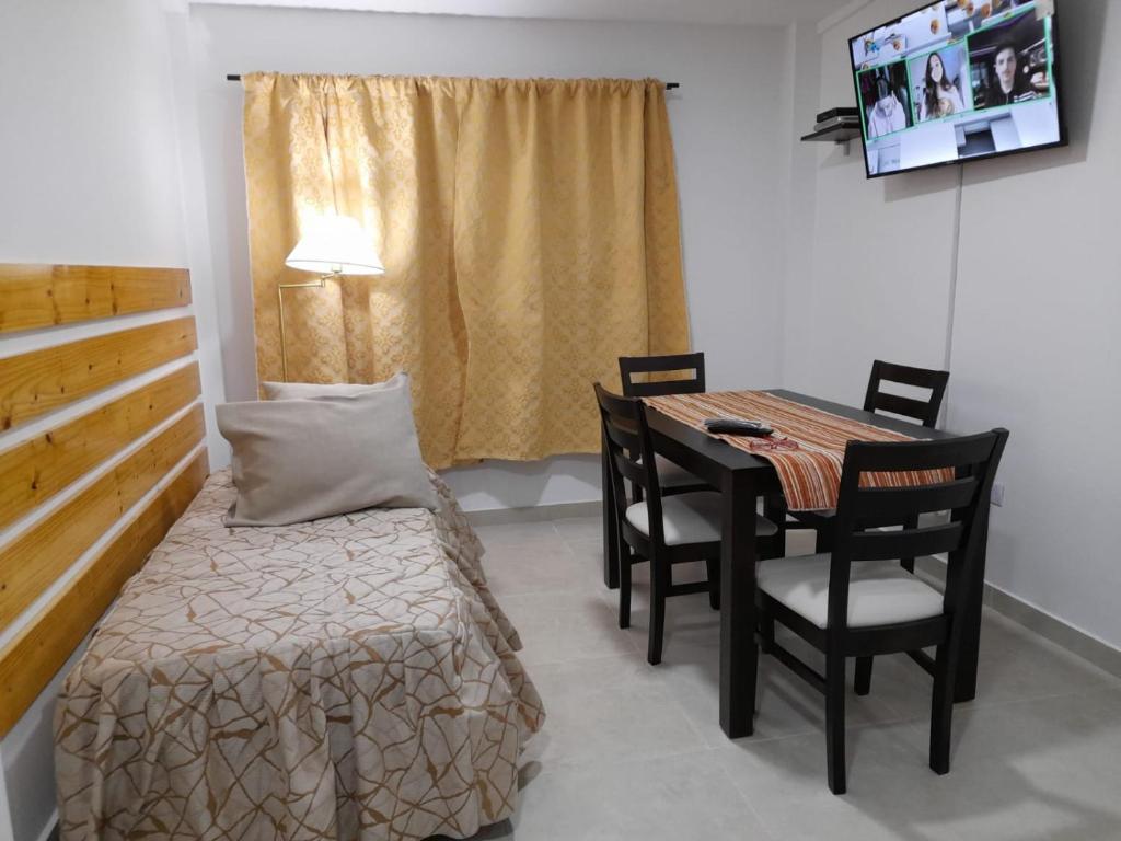 una habitación con una cama, una mesa y sillas en Las Lajas, en Ushuaia