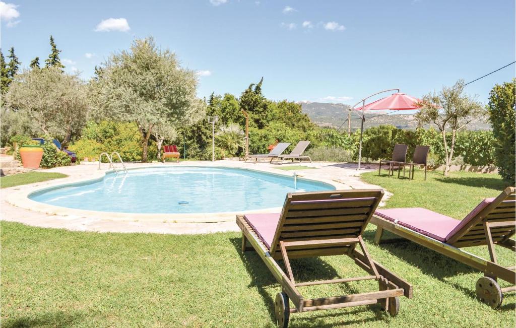 einen Pool mit zwei Liegestühlen und einem Sonnenschirm in der Unterkunft Nice Home In Sarrians With Wifi in Sarrians