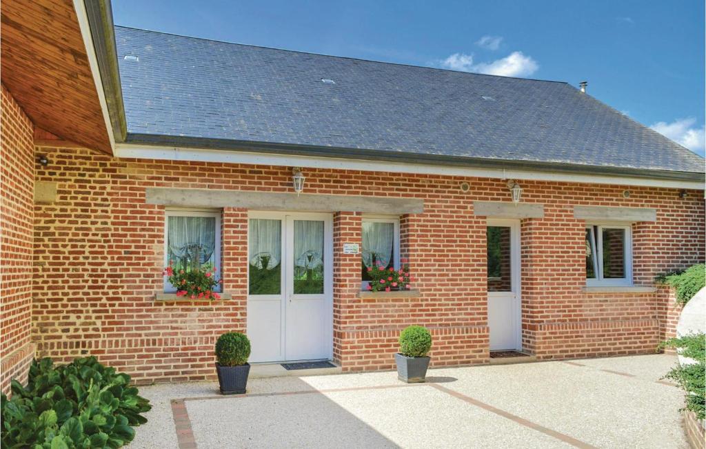 a brick house with two white doors and potted plants at Les Renoncules Des Champs in Roisel