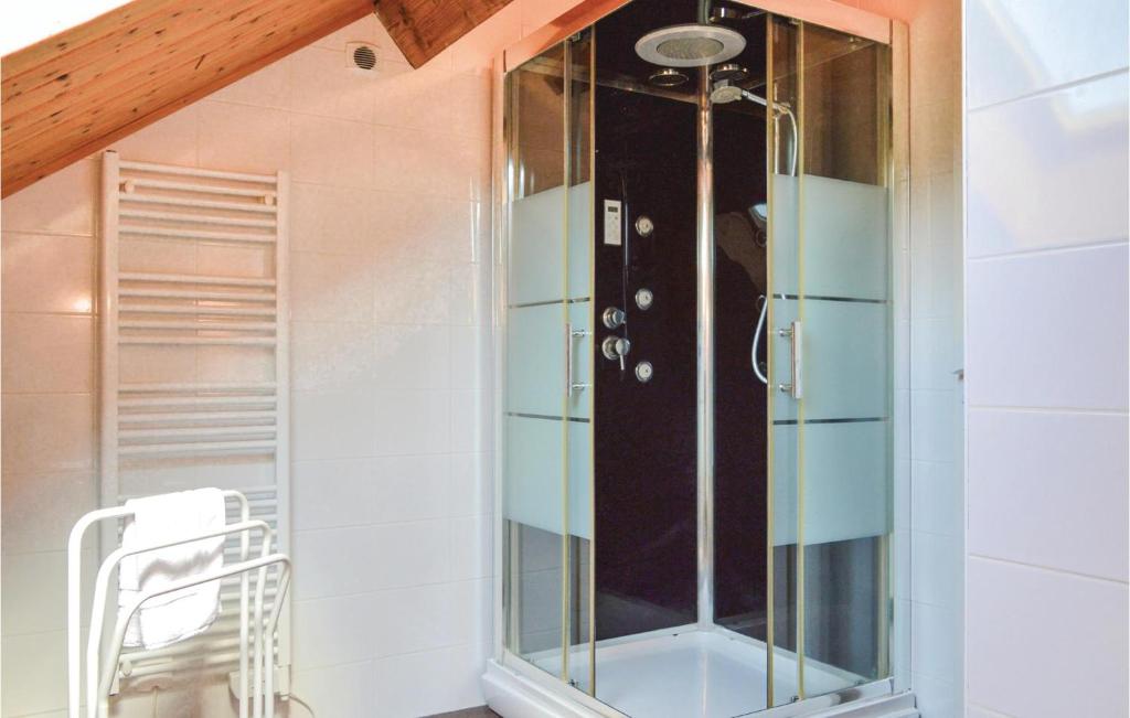a glass shower in a room with a chair at Les Renoncules Des Champs in Roisel