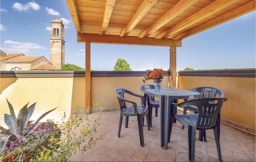 un patio con tavolo, sedie e torre dell'orologio. di Casa Lucia a Villadose