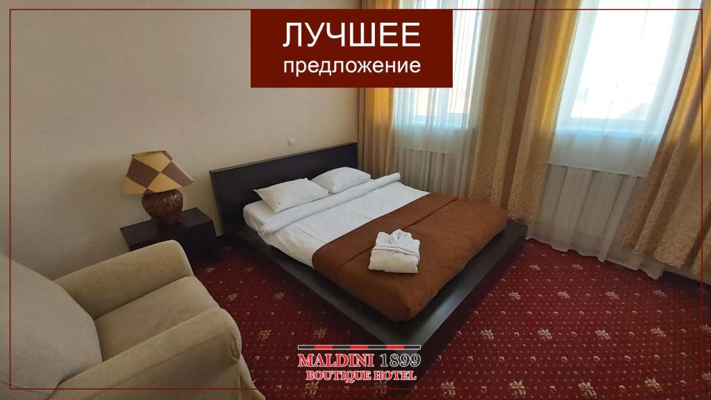 a hotel room with a bed and a couch at Maldini 1899 Boutique Hotel in Krasnodar
