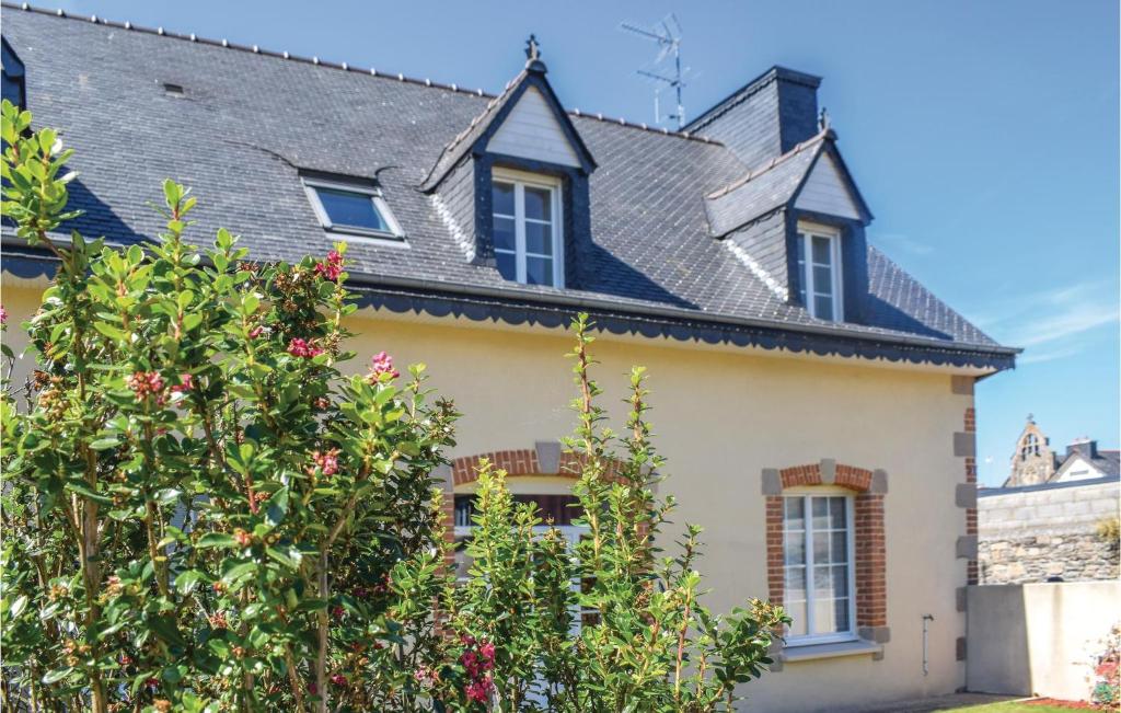 ein gelbes Haus mit schwarzem Dach in der Unterkunft Gorgeous Apartment In Treguier With Kitchen in Tréguier