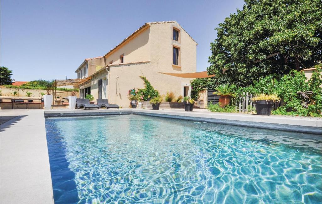 a swimming pool in front of a house at 4 Bedroom Awesome Home In Narbonne in Narbonne