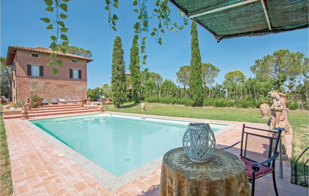 un jarrón sentado en una mesa junto a una piscina en Cozy Home In Castiglione Del Lago With Wifi, en Castiglione del Lago