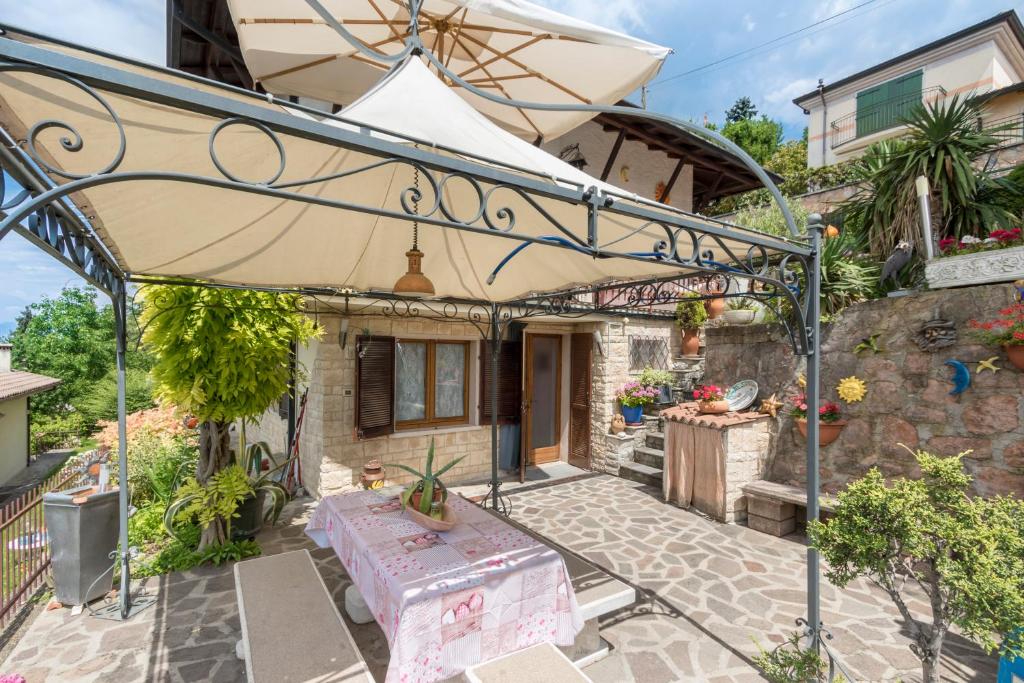 un patio con sombrilla frente a una casa en Casa Heli II, en San Zeno di Montagna