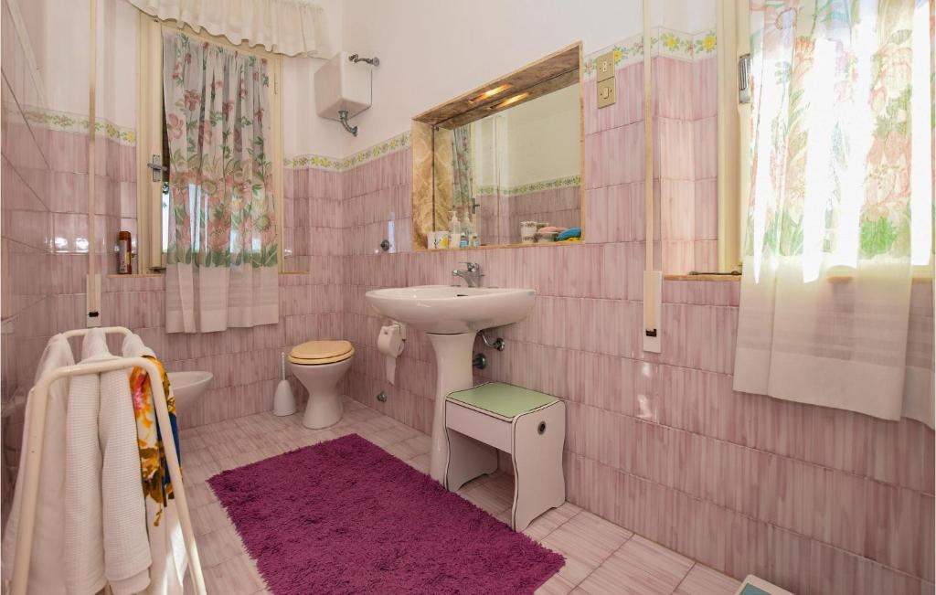 a pink bathroom with a sink and a toilet at Villa Arduino in Santa Liberata