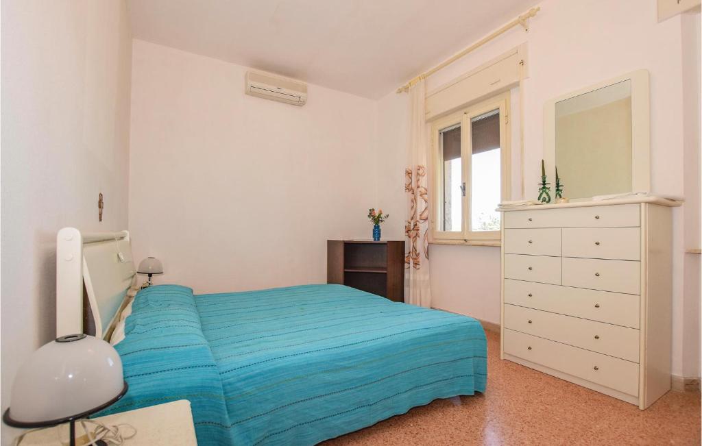 a bedroom with a blue bed and a dresser at Villa Arduino in Santa Liberata