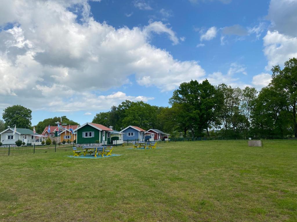 a park with houses and picnic tables in a field at Poppes Ranch Bauerhof & Campingplätze in Zepelin