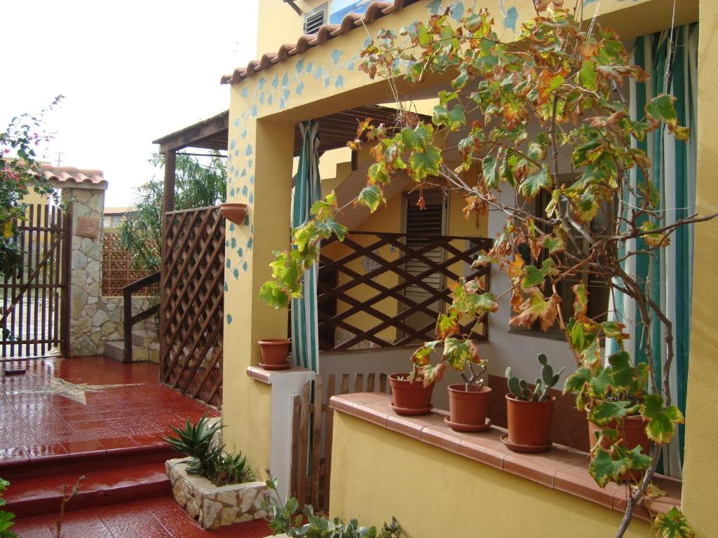 a house with potted plants on a balcony at Il Sole Di Lampedusa in Lampedusa