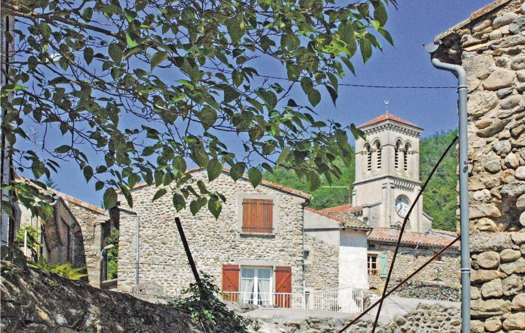 budynek z wieżą zegarową i kościołem w obiekcie Lovely Home In St, Fortunat S Eyrieux With Kitchen w mieście Saint-Fortunat-sur-Eyrieux