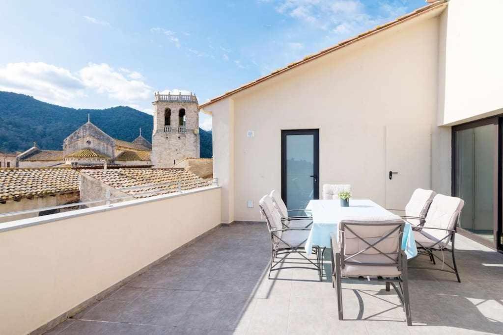 een patio met een tafel en stoelen op een balkon bij Besalú 3 modern apt w terrace y great views ac in Besalú