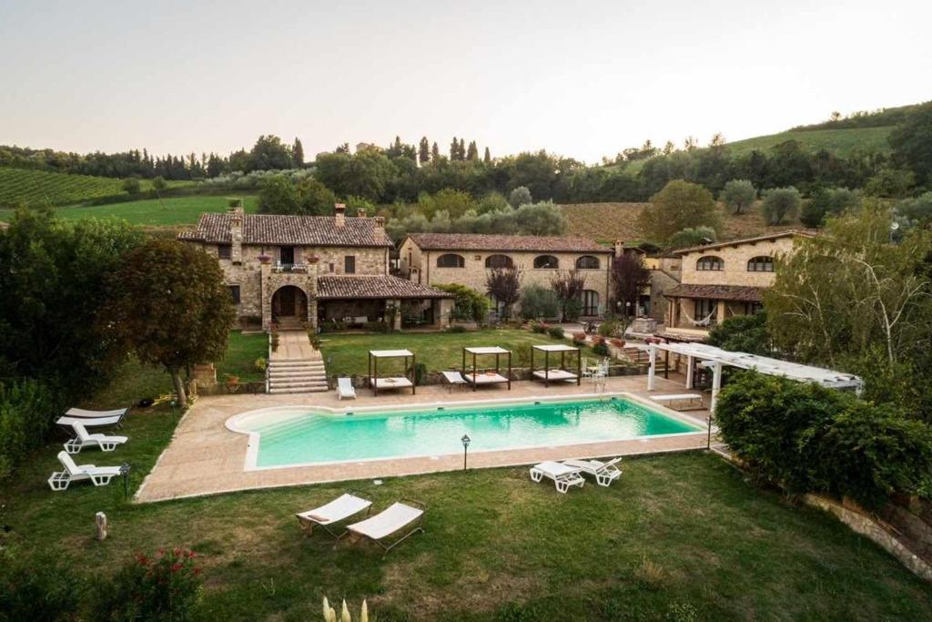 a large house with a swimming pool in the yard at Residenza Collefiorito in Todi