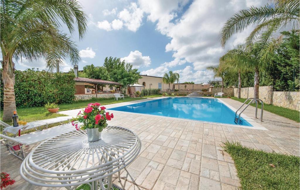 a swimming pool with a table and a vase of flowers at App,to Fiordaliso in Balestrate