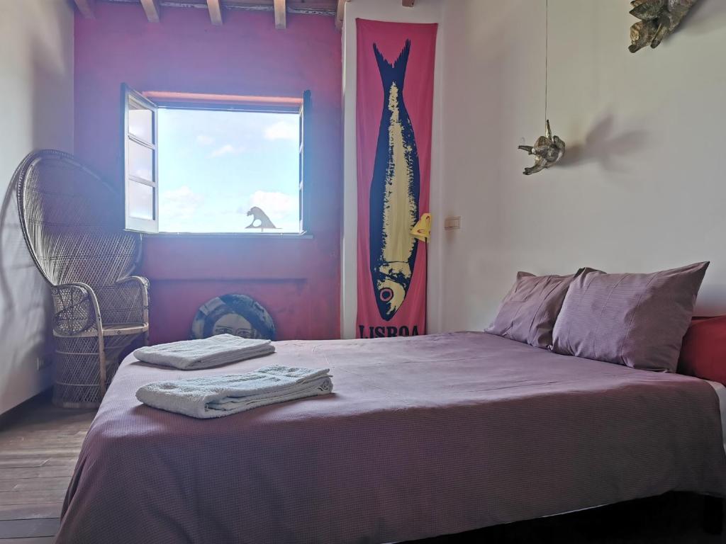 a bedroom with a bed with purple walls and a window at Hostel Argonauta in Óbidos