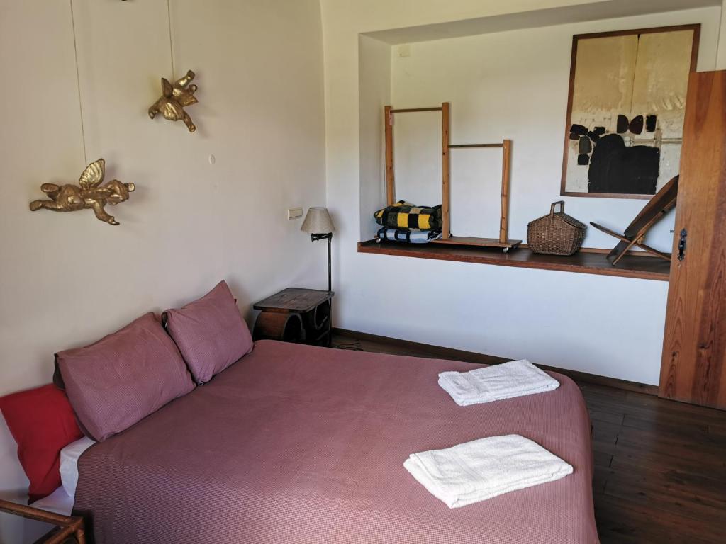 a bedroom with a bed with two towels on it at Hostel Argonauta in Óbidos