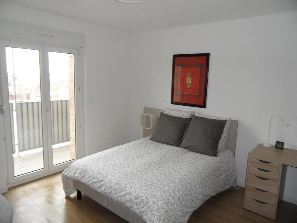 a white bedroom with a bed and a window at # STUDIO BON EMPLACEMENT AVEC PARKING # in Illzach