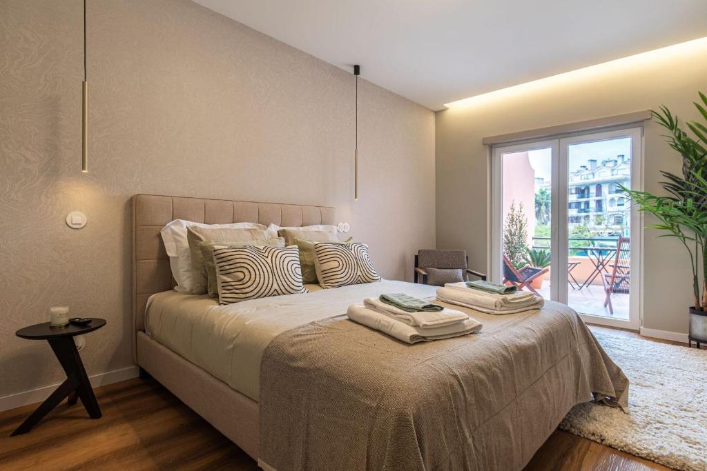 una camera da letto con un grande letto con cuscini sopra di Deluxe 2BDR Apartment in Carcavelos by LovelyStay a Carcavelos