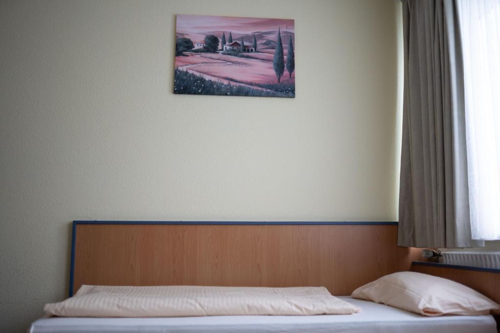 ein Bett in einem Schlafzimmer mit einem Bild an der Wand in der Unterkunft RadlStadl - Brauhaus und Hotel in Kaarst