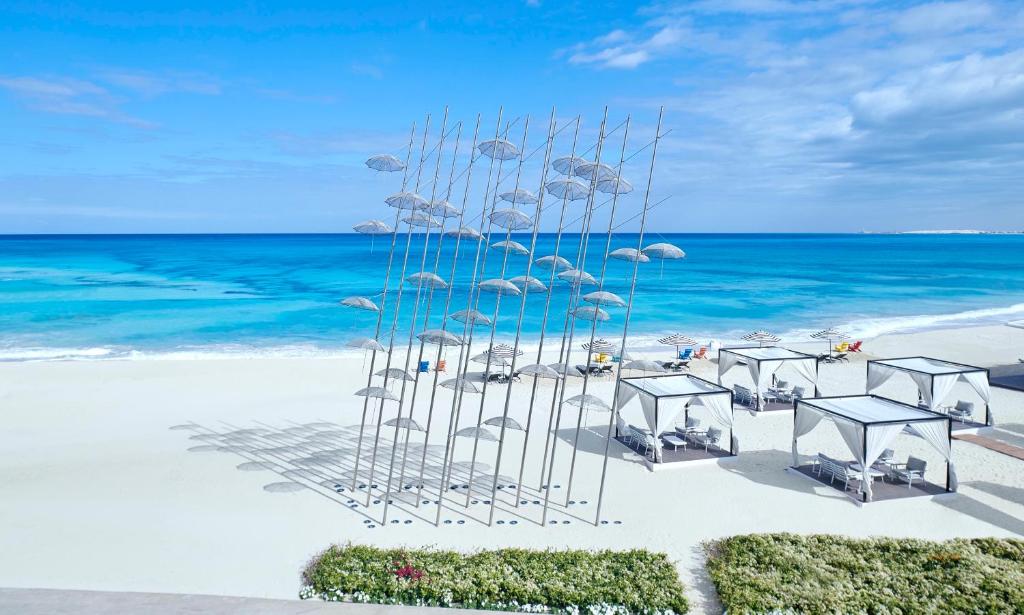 Al Alamein Hotel في العلمين: مجموعة من الكراسي والطاولات على الشاطئ